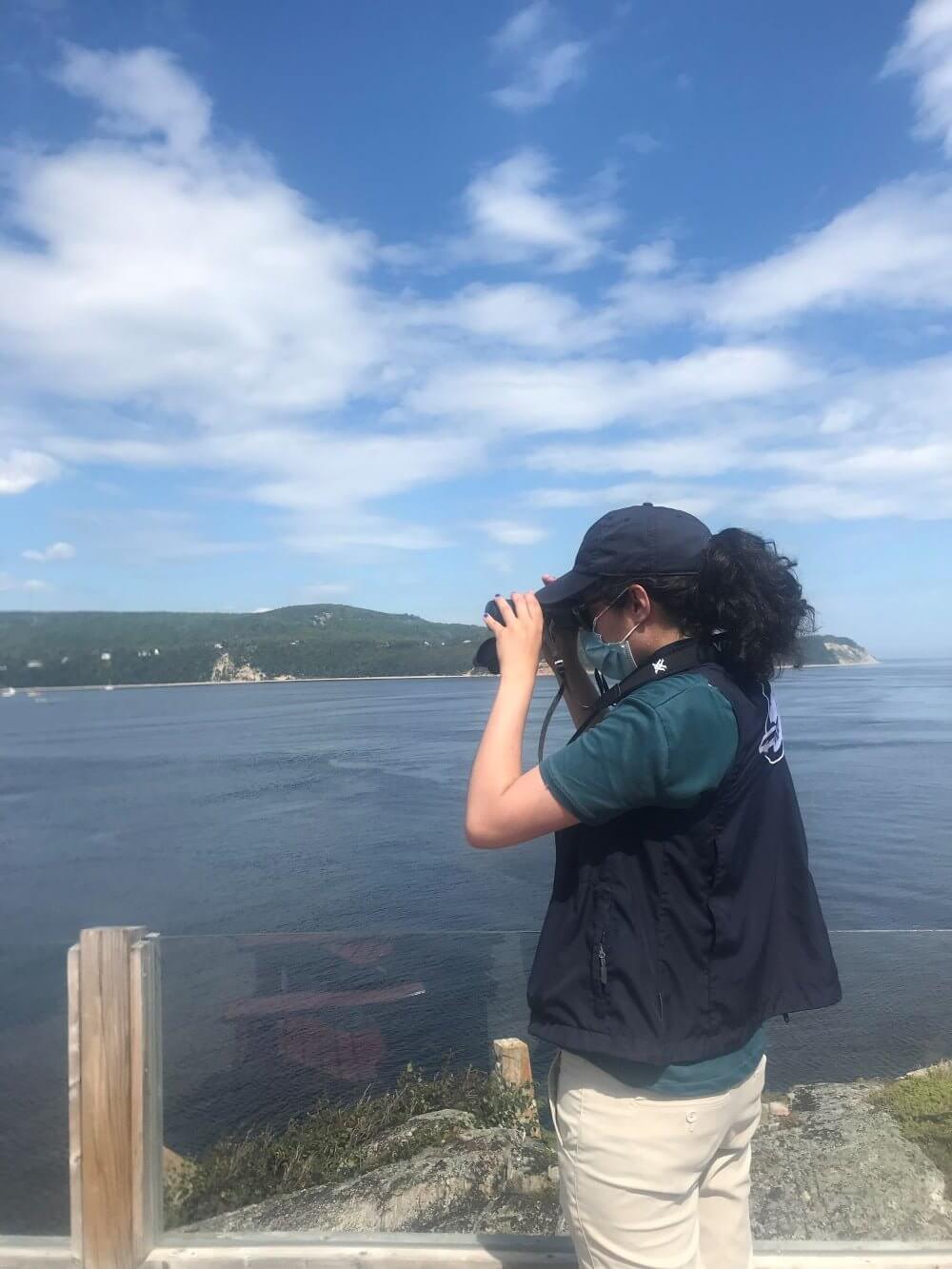 A naturalist uses her binoculars at Pointe-Noire